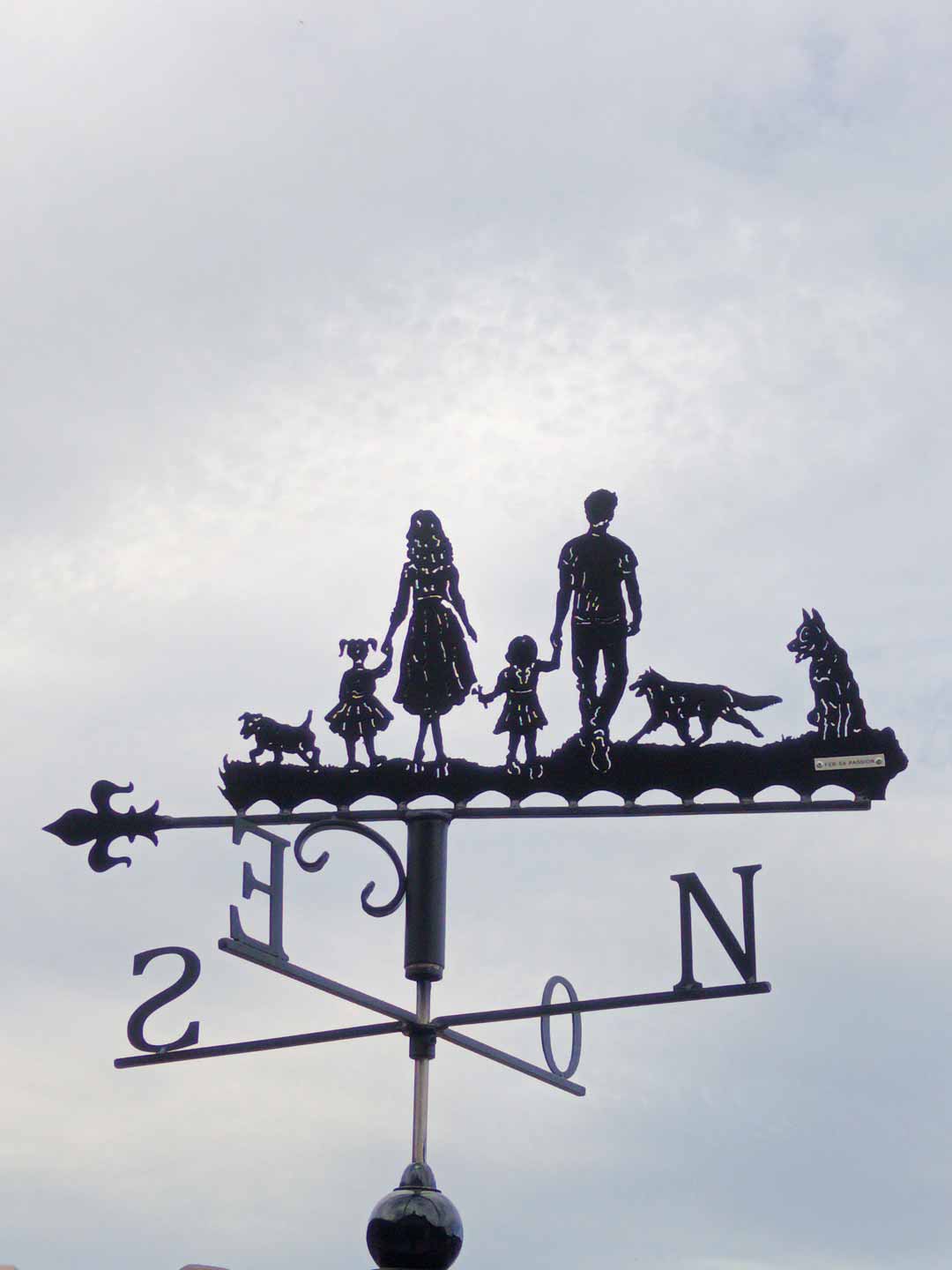 Une girouette représentant une famille et ses trois chiens