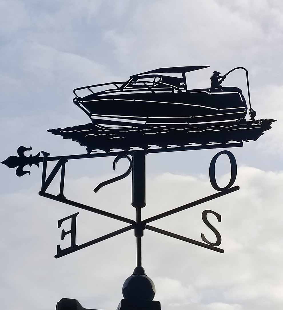 Une girouette représentant un petit bateau et un homme en train de pêcher
